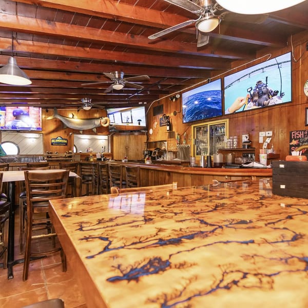Rustic bar interior with wooden walls, ceiling, and a unique fractal-patterned bar top.